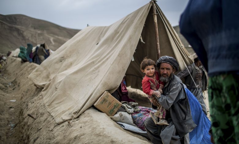 A displaced villager and his child in a tent after a landslide devastated their village, in abi barak, badakhshan province, afghanistan.