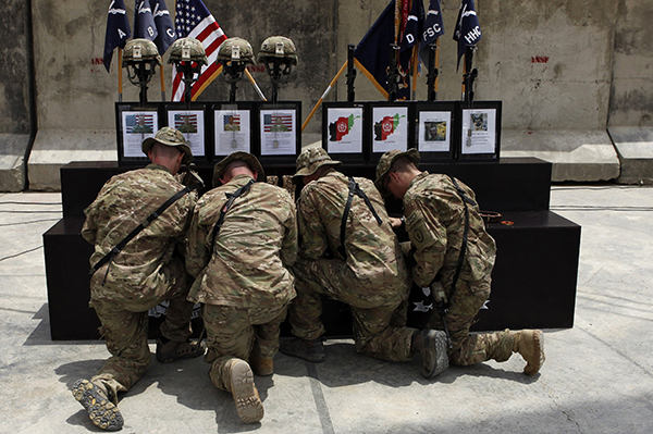 U.s. soldiers kneel at memorial to fallen comrades in afghanistan